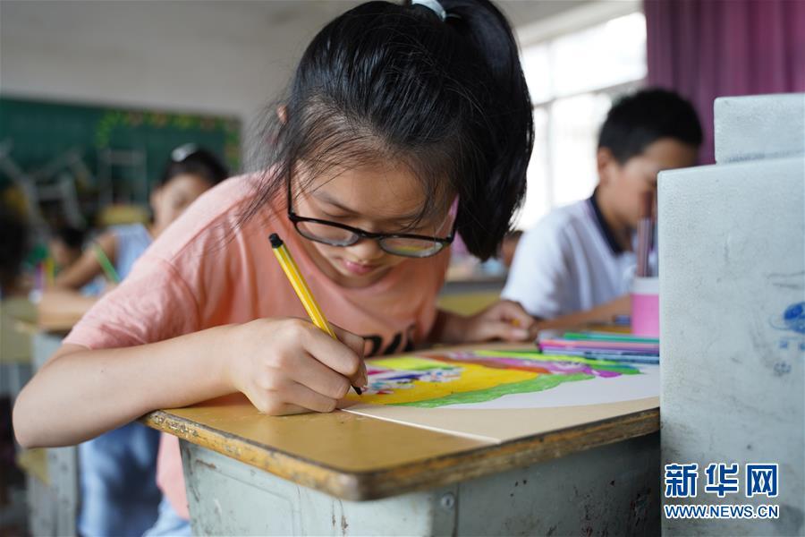 7月23日,在庐山市蛟塘镇中心小学安置点,小朋友在美术课上绘画.